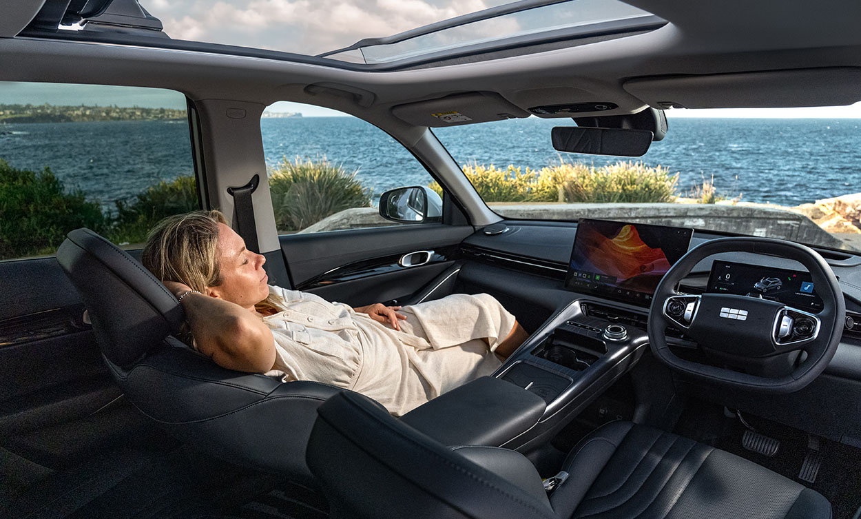 A woman lounging in a passanger seat of a Geely SUV