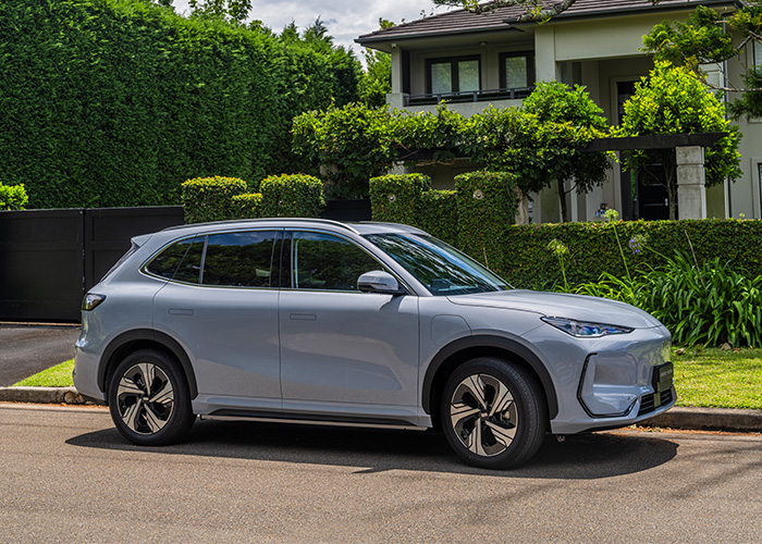Side profile of a silver Geeely SUV parked