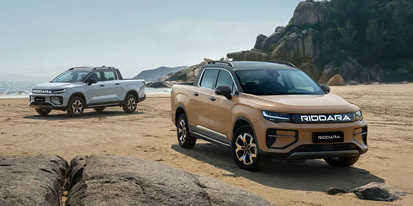 A tan and silver Riddara ute on a beach