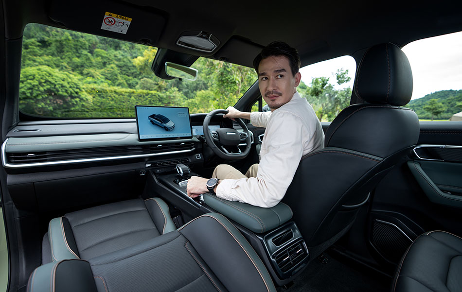 A man looking over his shoulder in the drivers seat of a Riddara