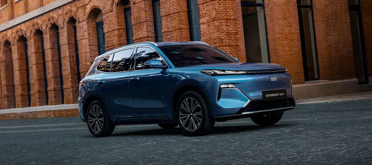 A blue Starray SUV driving infront of a brick building